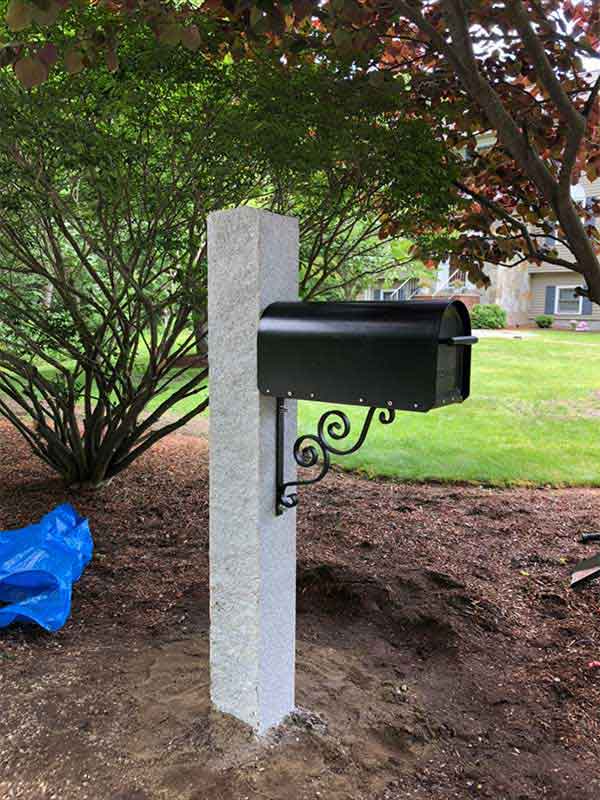 New Black Metal Mailbox added to grey concrete post with fresh dirt around it